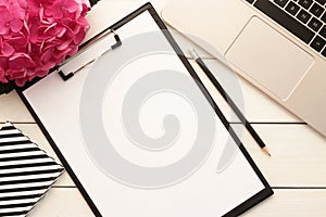 Office desk table with computer, supplies and flowers