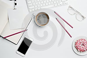 Office desk table with computer, supplies, phone and coffee cup.