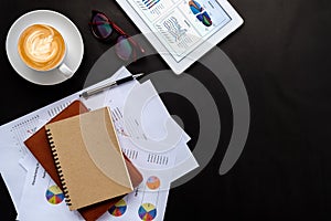 Office desk table with financial data on screen tablet