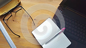 Office desk table with glasses, laptop, phone, notebook and ruler