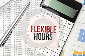 Office desk table with keyboard, notepad ,chart and calculator. Top view , text FLEXIBLE HOURS