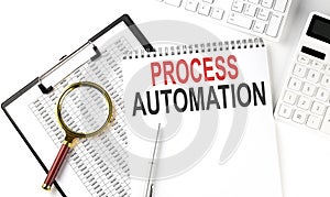 Office desk table with keyboard, notepad ,chart and calculator. Top view with text PROCESS AUTOMATION