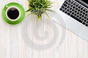 Office desk table with laptop computer coffee cup and flower