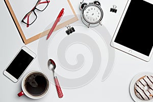 Office desk table with laptop, supplies, phone and coffee cup.