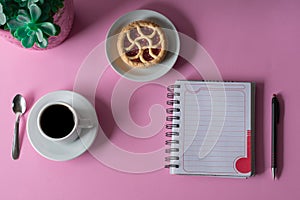 Office desk table with notebook and pen and a cup of coffee. Top view photo