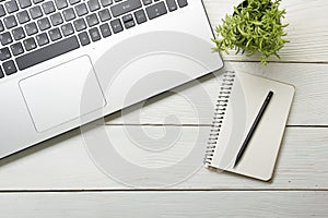 Office desk table with supplies. Top view. Copy space for text. Laptop, notepad, pen and flower.