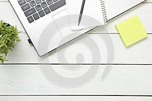 Office desk table with supplies. Top view. Copy space for text. Laptop, notepad, pen and flower.