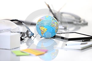 Office desk with tablet, headphones, and globe