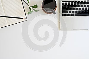 Office desk top view table with laptop, coffee, plant, notebook and pencil