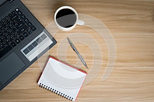 Office Desk Top view Workplace With Wooden Desk, Laptop, Notepad, Pen and Dark Hot Coffee