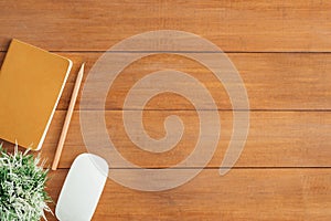 Office desk wooden table background with mock up notebooks and pencil and plant.