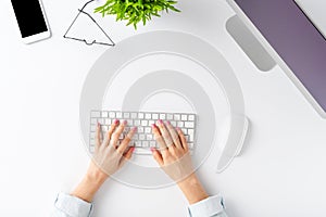 Office desktop concept. Womanâ€™s hands working on computer with business accessories on white background.