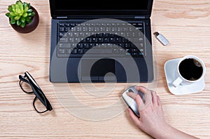 Office desktop setup with female hand holding wireless computer