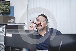 An office employee brainstorming for ideas. Biting his ballpen while thinking and analyzing