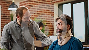 Office employee with neck collar brace working after accident injury