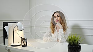 Office employee young woman is procrastinating sitting at work at the office table.