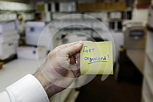 Office With Files Hand Holding Sticker Saying Get Organized