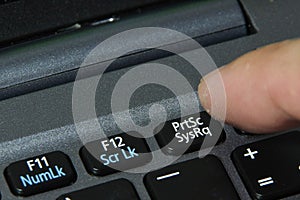 Office guy pressing print screen button on computer keyboard photo