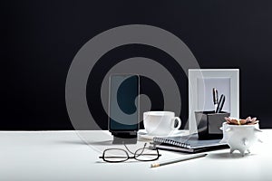 Office or home Office workspace. Desktop with smart phone template blank, notepads pens office suppliers cup of coffee