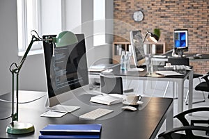 Office interior with computers and tables. Workplace design photo
