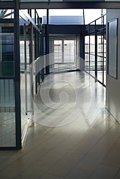 Office, interior and hallway with glass windows in passage or corridor of modern workplace. Empty corporate building