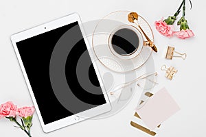 Ipad with gold desk accessories and pink flowers in a white background photo