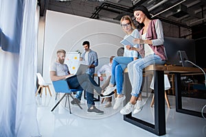 Office life. Group of young business people working and communicating together in creative office.