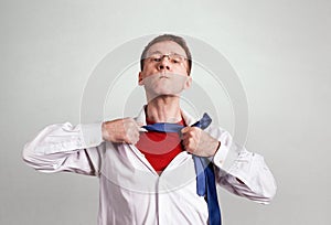 The office man opens a white shirt on his chest and shows a red T-shirt. Gray background