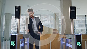 Office man unlock turnstile using smartwatch in business center. Man greeting