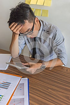 Office man worried about bad financial data on tablet