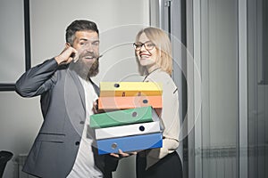 Office manager help woman colleague to carry binders with documents. Office romance and flirt concept