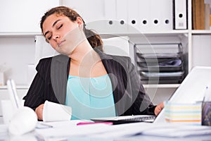 Office manager woman is sleeping at work after putting the reports