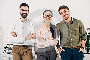 Office managers with arms crossed smiling and looking at camera photo