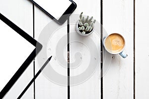 Office objects, devices with blank screens. White screen on smartphone and tablet on wooden table