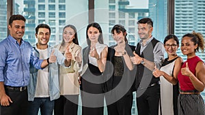 Office people teamimg up together and having thumps up to show team spirit