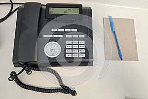 Office, phone and notepad with pen