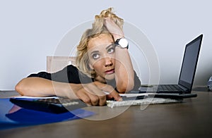 Office portrait of young sad and depressed business woman working lazy at laptop computer desk feeling bored and tired looking tho