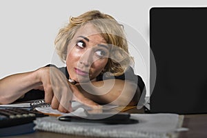 Office portrait of young sad and depressed business woman working lazy at laptop computer desk feeling bored and tired looking tho