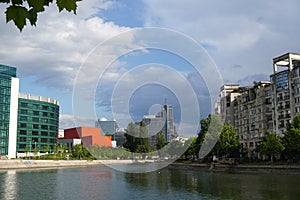 Office and residential buildings on Dambovita river shores in sunny day in Bucharest