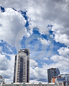 Office and residential skyscrapers on clear blue sky and clouds background