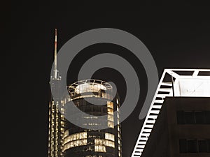 Office skyscraper with antenna and helipad at night