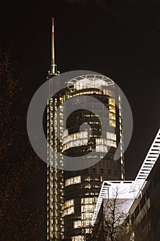 Office skyscraper with antenna and helipad at night