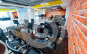 Office space interior. View from above. Modern ofice furniture. Open space for managers. Bricks wall and wooden tables.