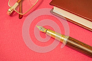 Office still life red table with a notebook, gilt pen and glasses businessman prepare for notes