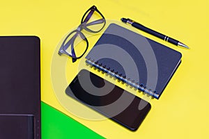 Office stuff with pen, paper notebook,smartphone,laptop eyeglasses.Top view.Working colorful desk table