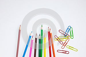 Office supplies concepts, Colored crayon pencils and clips on white background