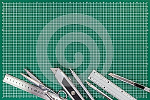 Office supplies on cutting mat - cutters, scissors, mechanical p