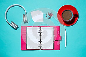 Office supplies. Top view on opened notebook, pen, headphone and