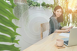 Office table with Asian woman in smiling face with coffee cup an