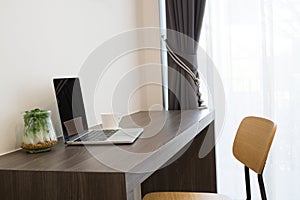 Office table with blank screen laptop, white coffee cup, modern